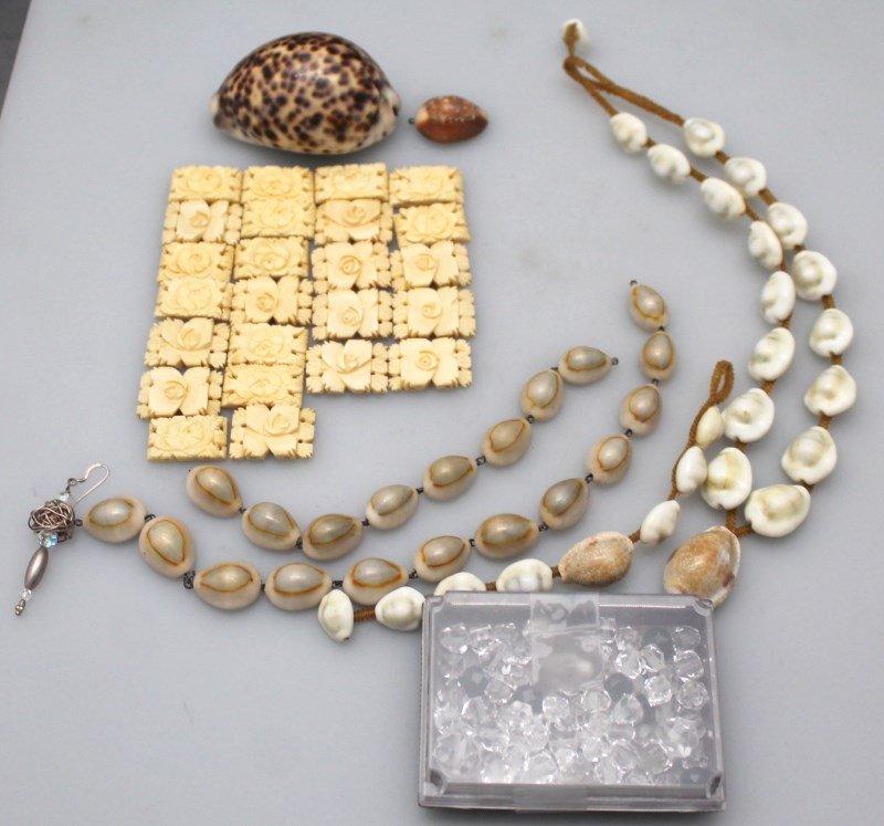 LOT VINTAGE CARVED BONE ROSE - COWRIE SHELLS + MORE: A great lot for the remaker. There is a cowrie shell and leather bracelet and necklace. There is also a bag of loose cowrie shells and carved bone roses. In addition there is a box of crystal beads. P