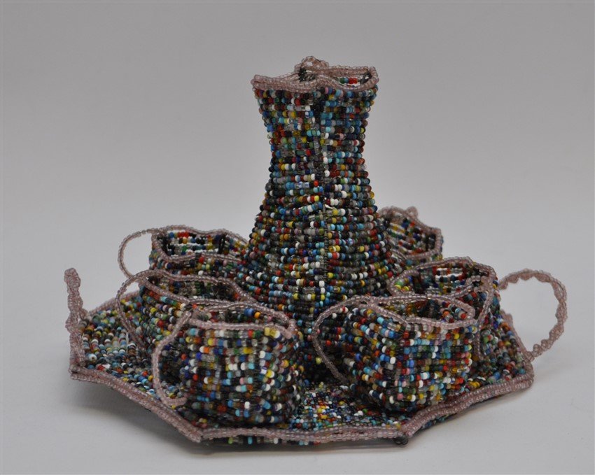 SOUTH AFRICAN BEADED DRINK SET: Delightful Vintage South African Beaded Tray with six small cups and a Carafe. Multi colored glass beads, for display only. Tray measures 6x6 and carafe is 3.50 tall. Weight is 8.4 oz.