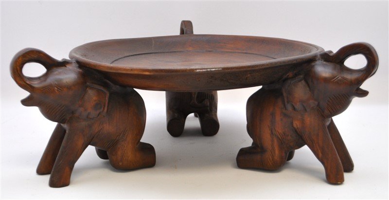 HAND CARVED ELEPHANTS PEDESTAL CENTERPIECE: Large Hand Carved Wood Triple Elephant Pedestal Serving Plate /Bowl / Centerpiece. All three elephants with raised trunks. Measures 17x17x6". Weight is 5 pds. PROVENANCE: A Charleston SC Private Estat