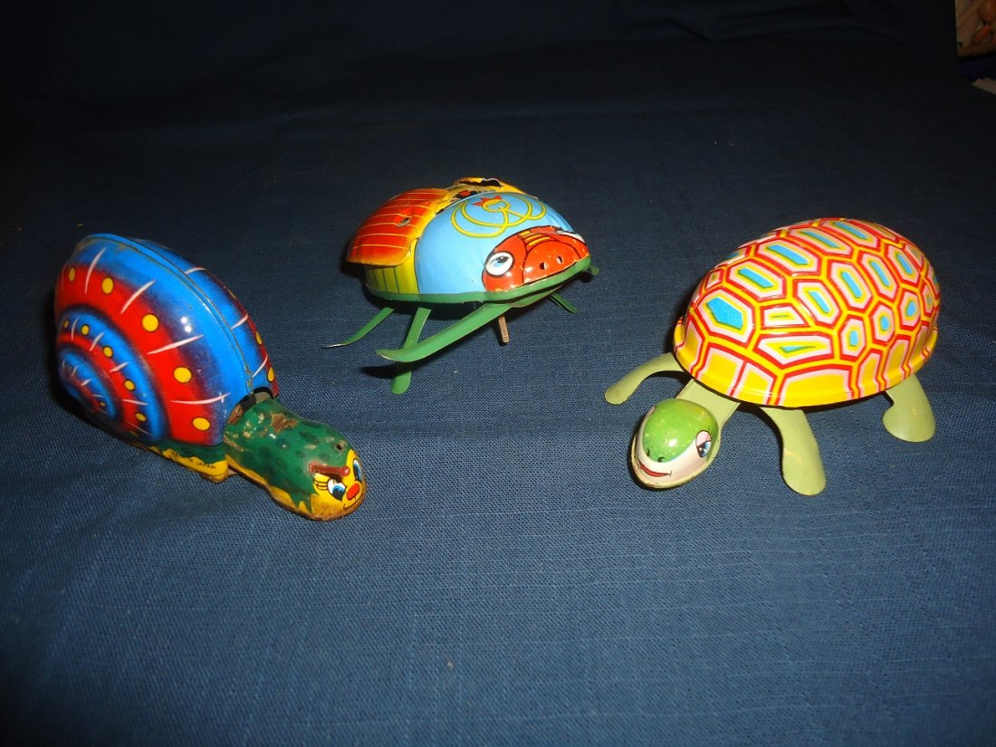 Three Lithographed Toys: Snail missing one antennae, friction toy, minor surface rust. The big bug is keen, winds up- wings flap- working order Japan. 5\" in length. Turtle, wind-up, no movement- nice litho surface. Good surf