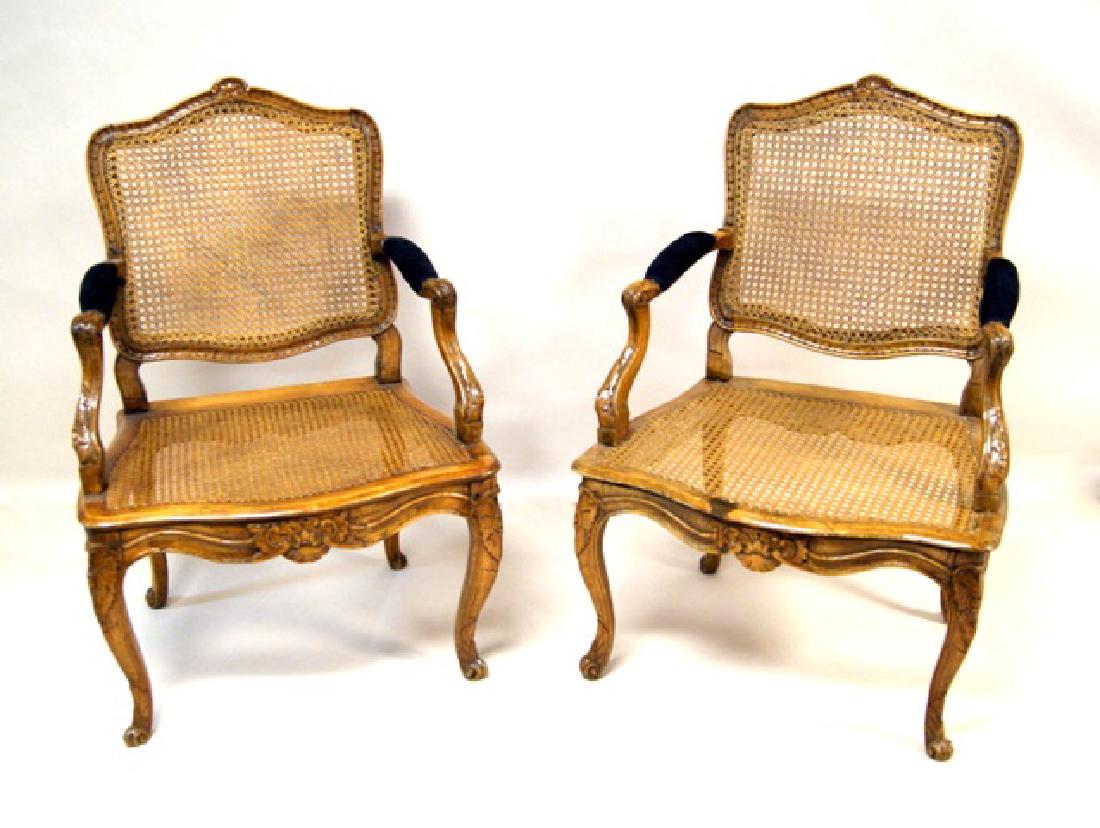 Pair French Antique Mahogany Armchairs: Pair of French 19th century mahogany armchairs, floral carving on crests, arms and apron, cane backs and seats in good condition, 36"H, 25"W, 24"D