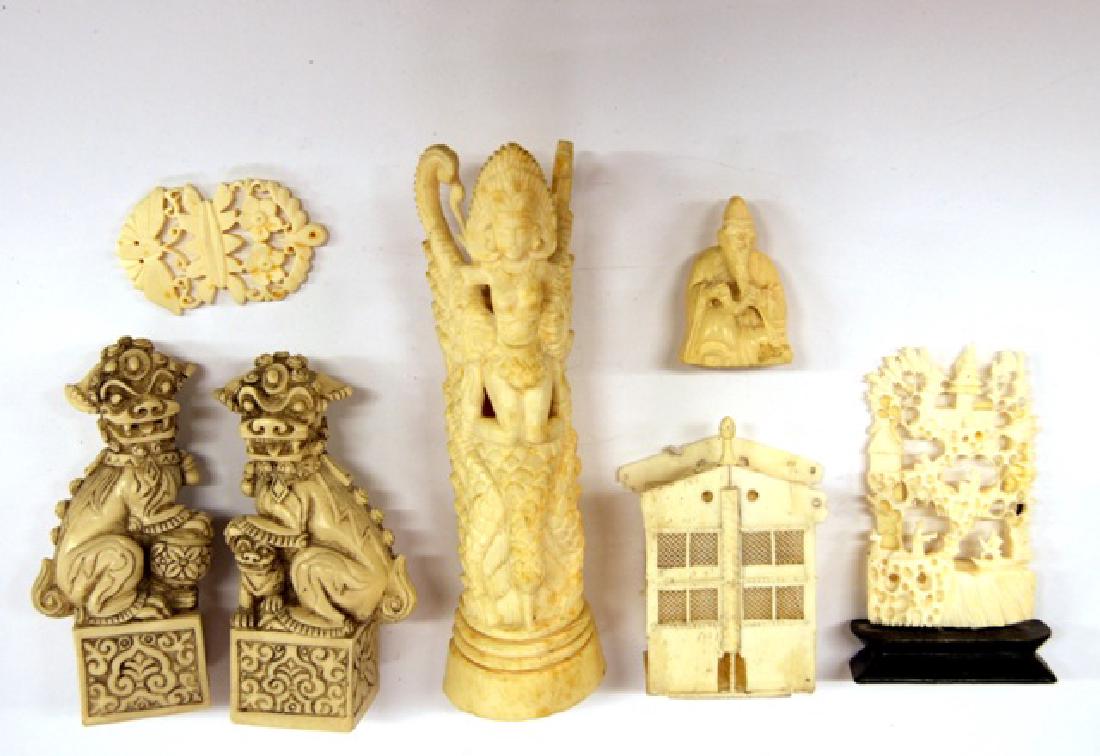 Group of Bone Carvings & Others: Bone carving of Goddess kneeling on bird 6"H, small sitting scholar 1.75"H, reticulated carving on wood base 3.5"H, floral pendant 2.25"H, sedan chair with losses 2.75"H, pair of cast foo dogs 4"H