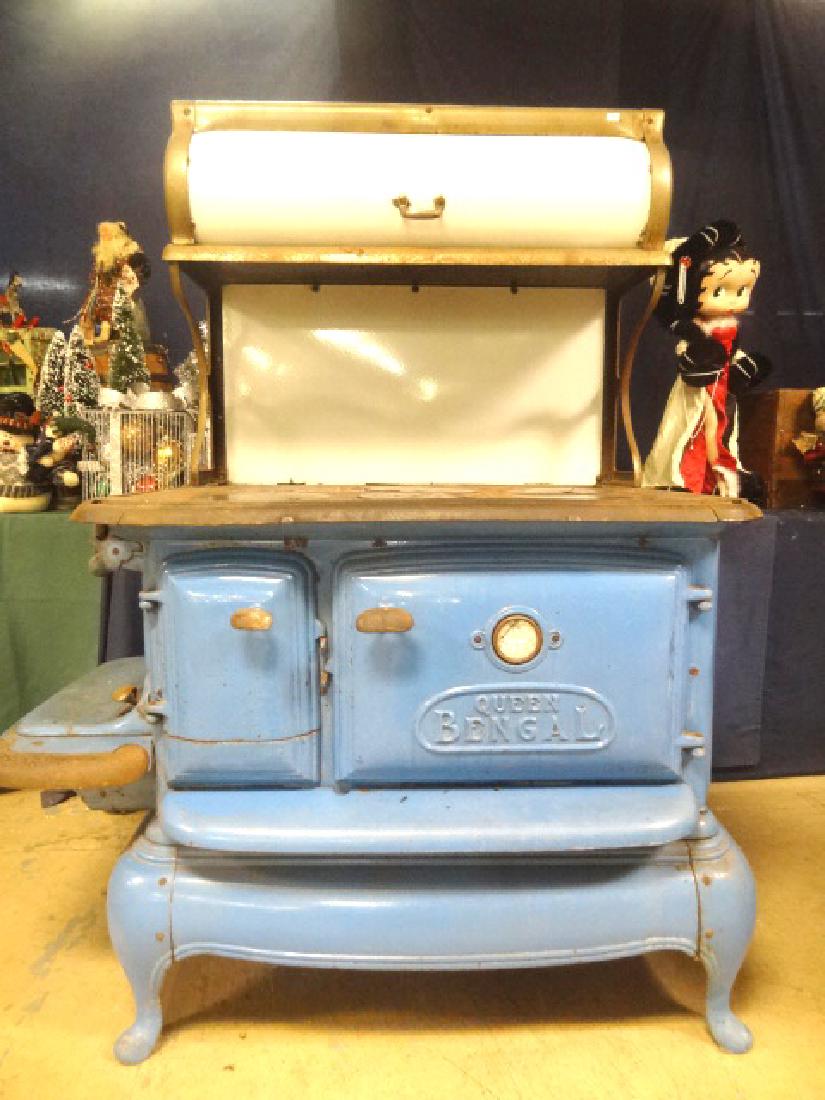 Antique Queen Bengal Wood Cook Stove: Antique Circa 1920s wood stove with six burners, oven and warming unit white enameled steel top with roll cylinder door and plated trim, iron cook surface with six plates, blue enamel case has fuel bo