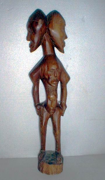 Wood carving of two conjoined heads