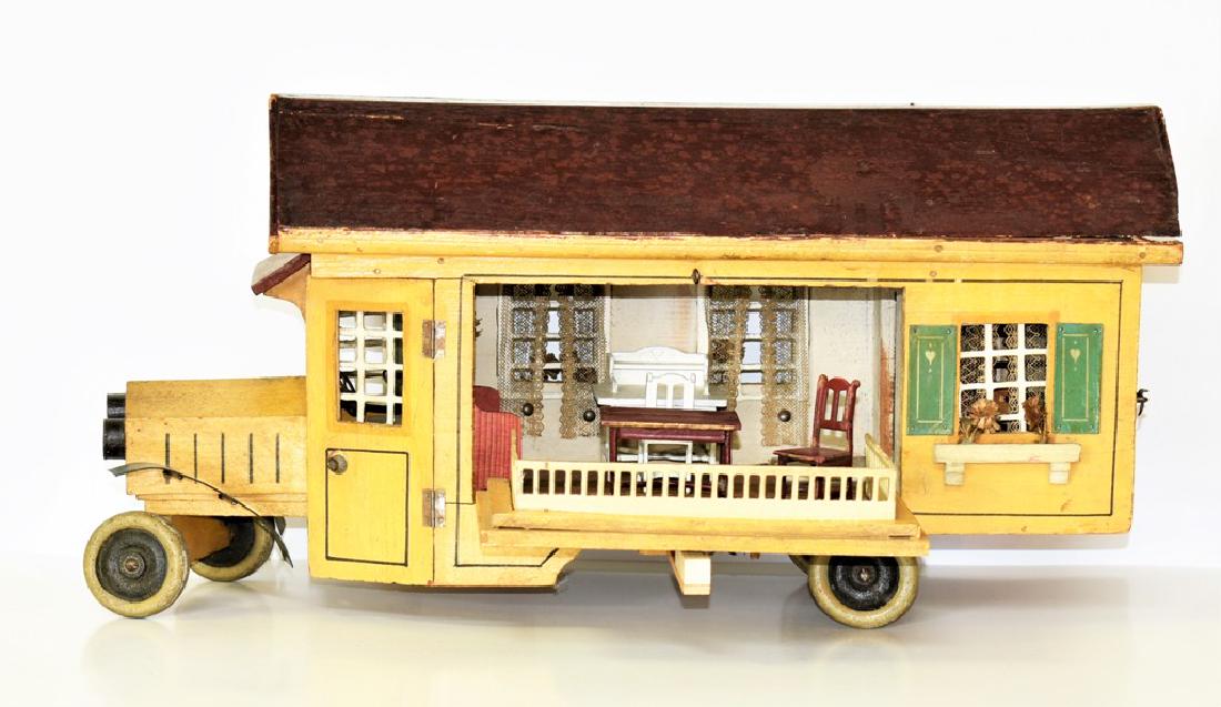 Antique Dollhouse Two Room Travel Bus: Unusual painted wood two room bus dollhouse, tin wheels, front fenders and trim, hinged doors to driver's cab, side opens to main room and converts into a patio, room has original paper floor and smal