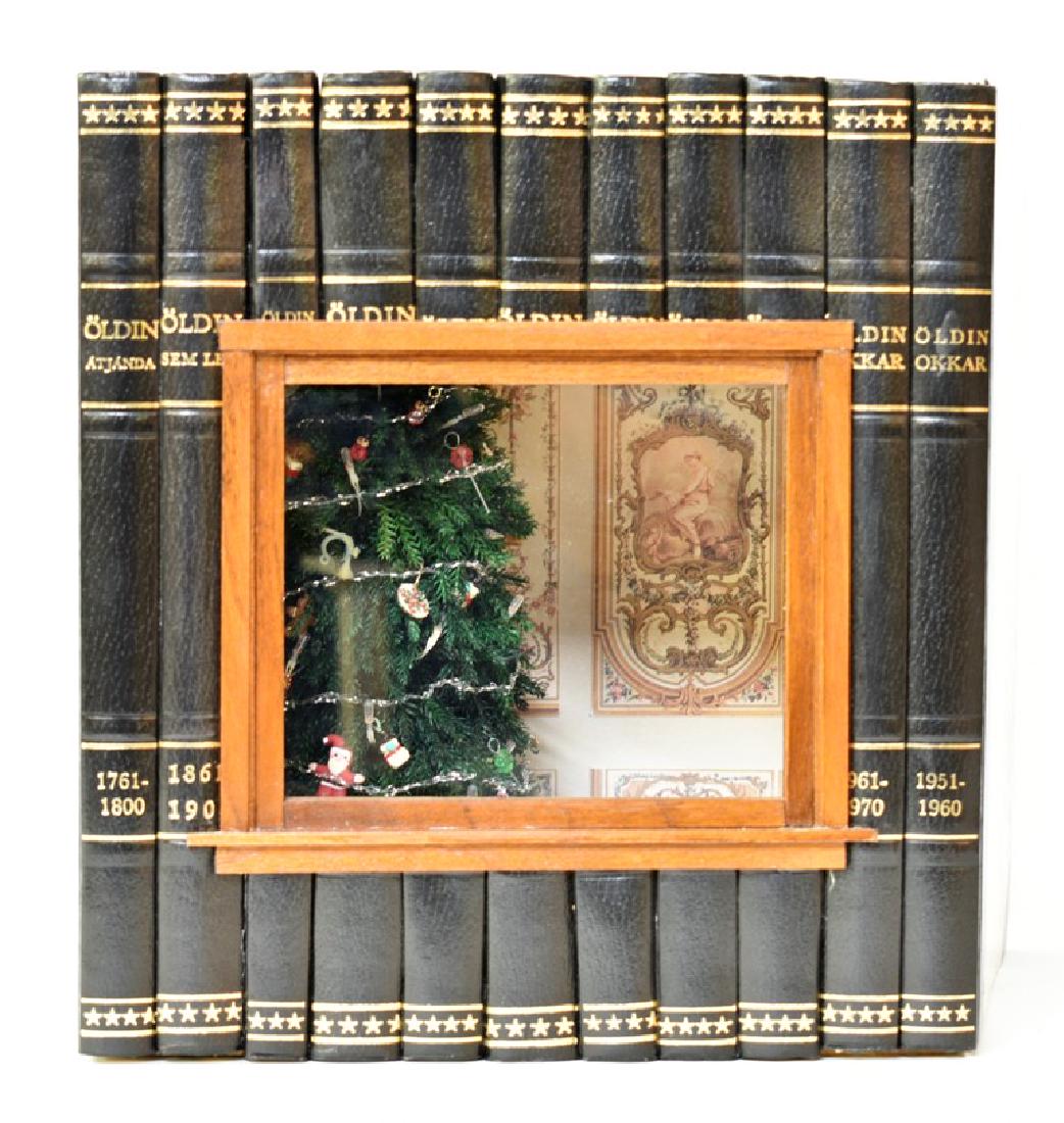 Shannon Moore Xmas Books Room Box Dollhouse: Shannon Moore artisan Christmas room box made from hollowed out set of books, large window in front gives view of small room with decorated tree, wallpaper and tile floor, electric light in ceiling, a