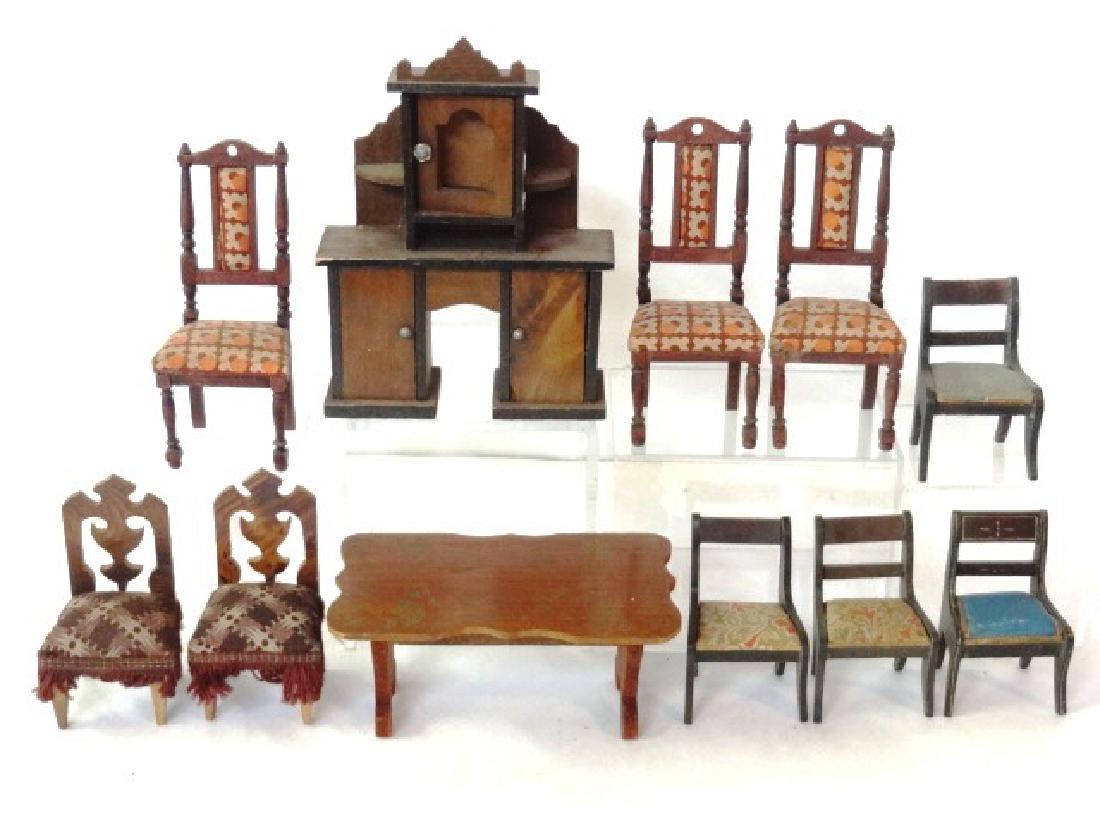 Antique German Dollhouse Dining Room Furniture: Antique German sideboard 4.25"W, stencil decorated table 5"W, set of three side chairs 4.75"H, pair of upholstered chairs with fringe 3.5"H, mirror with pressed design, assorted chairs