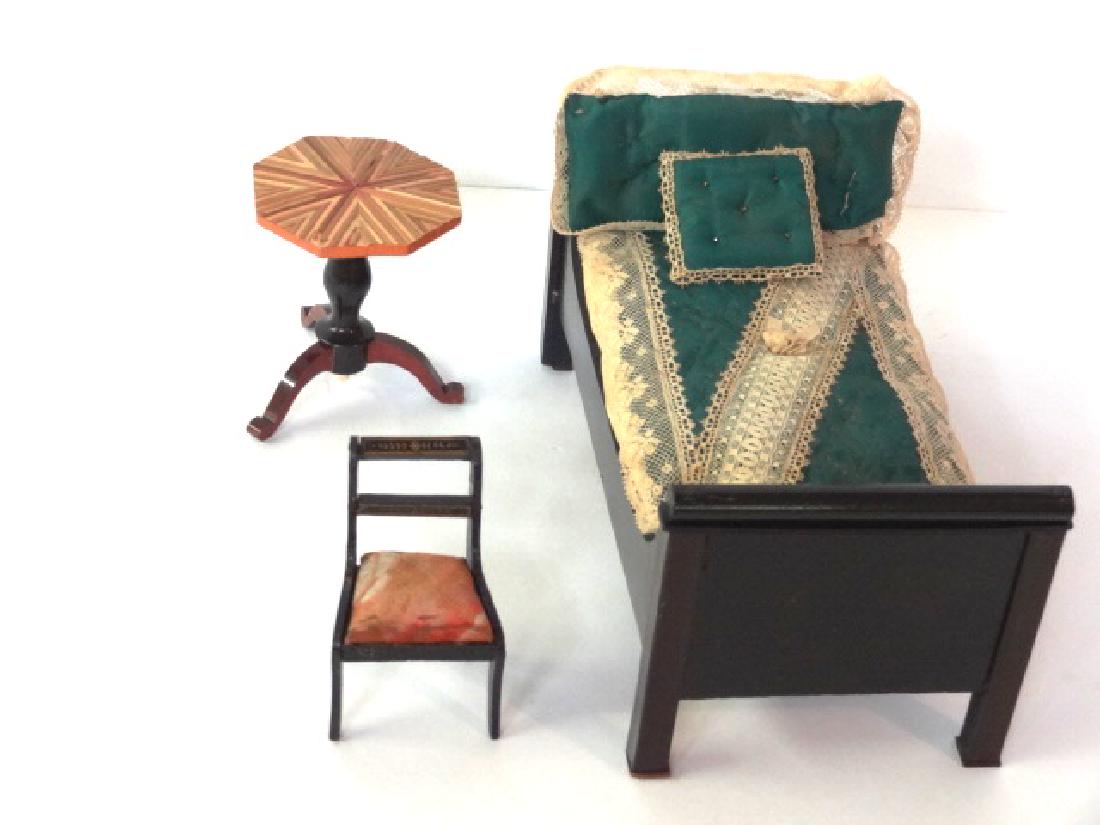 Antique Dollhouse Biedermeier Bed, Table & Chair: Antique German Biedermeier bed with original finish, includes padded mattress, pillows and coverlet trimmed in lace 8.5"L, 4.5"W, 4"H, paint decorated sabre leg chair 3.5"H, tripod table with straw in