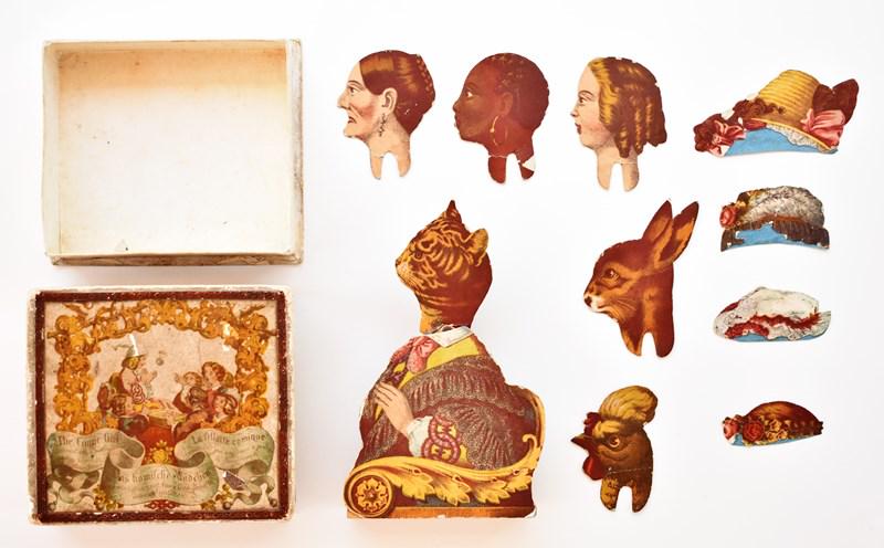 Comic Girl Swinging Paper Doll Toy: Mid-19th century boxed toy The Comic Girl, two piece box printed in English, German and French has small losses and a .5" section of top colored in, hand colored lithographed paper over wood body hold