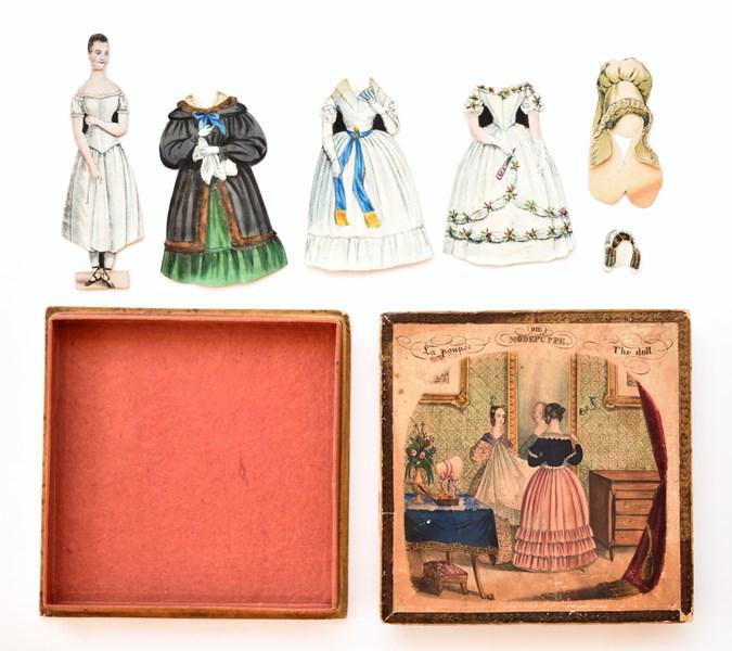 "The Doll" Early Boxed Paper Doll Set: Mid 19th century boxed paper doll set The Doll, hand colored two piece box printed in English, French and German, 5" front and back doll with neck bend, 3 front and back costumes and two front and bac