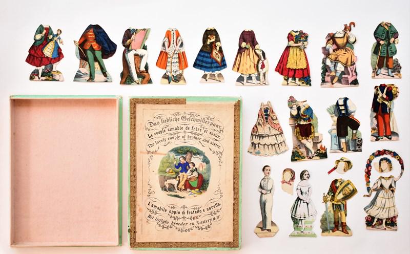 The Lovely Couple Of Brother and Sister Paper Doll Set: 19th century boxed paper doll set titled The Lovely Couple OF Brother and Sister, hand colored two piece box printed in English, German, French, Italian and Dutch 6.5" by 8.5" with two split flap corn