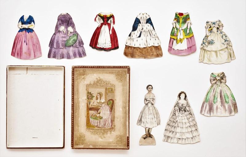 Early Paper Doll Boxed Set: Mid 19th century boxed paper doll set, original two piece hand colored box 5" by 7" has a 5" front and back doll with neck bend and repaired foot, 6 front and back dresses and a F&B wedding gown