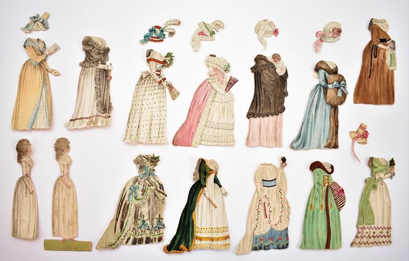 Early African & Caucasian Paper Doll Set: Unusual 19th century hand colored paper doll set with two dolls, #1 has African doll with French note on reverse 6"H, #2 Caucasian doll missing base, 12 dresses and 7 hats