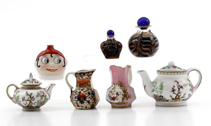 Doll Small China & Glass Accessories: Two hand blown glass perfume bottles 1 3/8" and 2"H, two antique pitchers 2"H, vintage painted glass googly eye bottle 1.75"H, two Coalport teapots in the Indian Tree pattern 2.5" and 3.5"L, from the