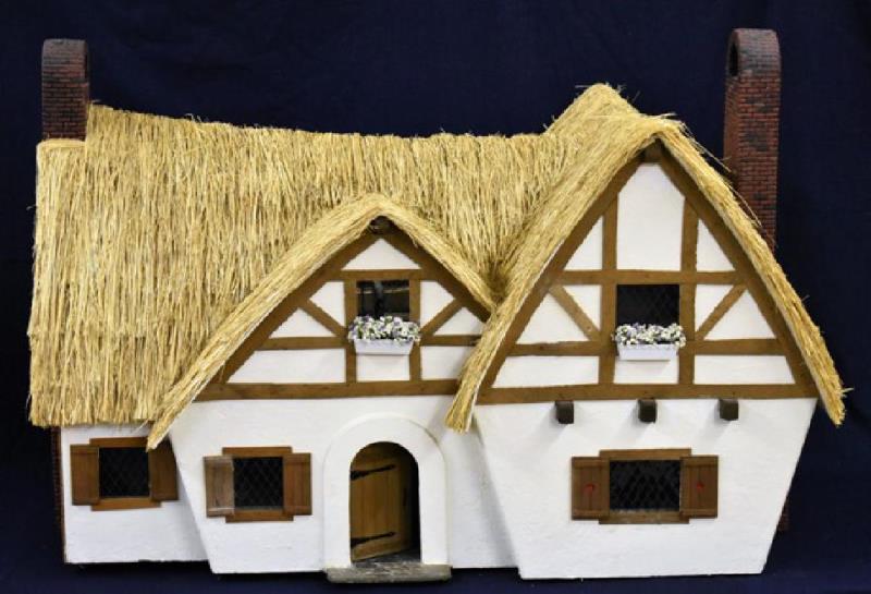 Thatched Roof Cottage Dollhouse: English style cottage dollhouse with half timbered exterior with white textured paint, real thatched roof, windows with painted mullions, two large chimneys, wood shutters and opening front door, firs