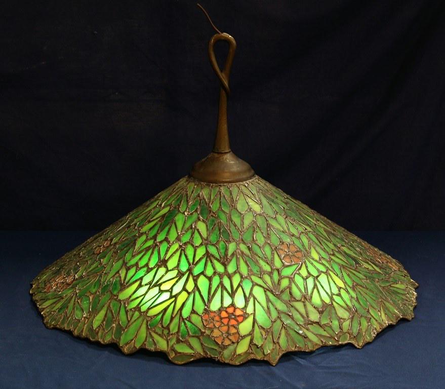 Green Leaded Glass Tiffany Style Hanging Lamp: Green Leaded Glass Tiffany Style Hanging Lamp , with lots of muted green colors, very stylish leading , appears to be styled after Tiffany. 10" tall, 26" W IMPORTANT please notice the pulls on this la