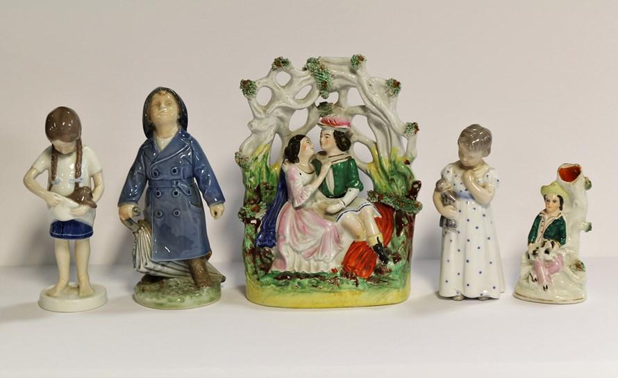 European Porcelains & China Figurines: B & Girl with cat 7" H, Royal Copenhagen Boy in rain 7" h, Bisque Girl with doll 5" H, Staffordshire Style courting couple 8" H, and spill vase of by holding a Spaniel