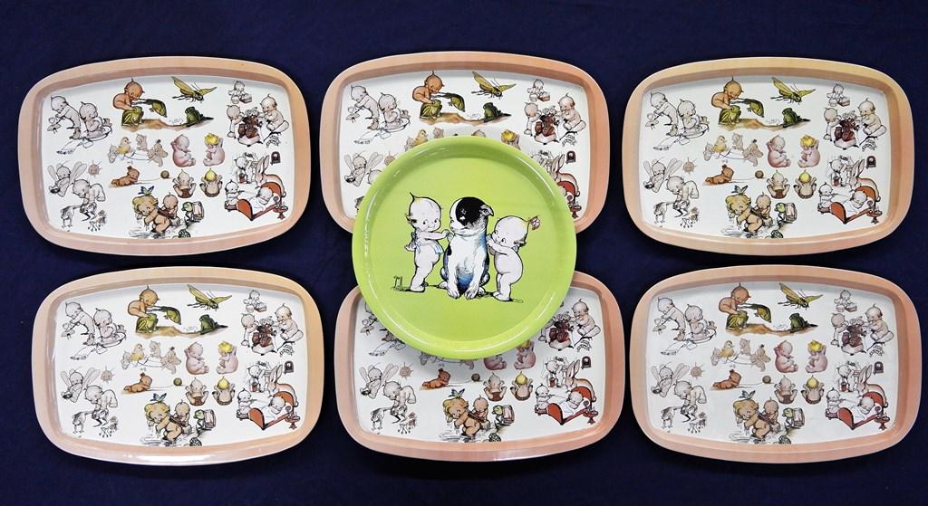 Seven Kewpie Tin Trays: Round tin tray with two Kewpies and doodledog 11.5"D, six matching tin oval trays 10.25" by 15"