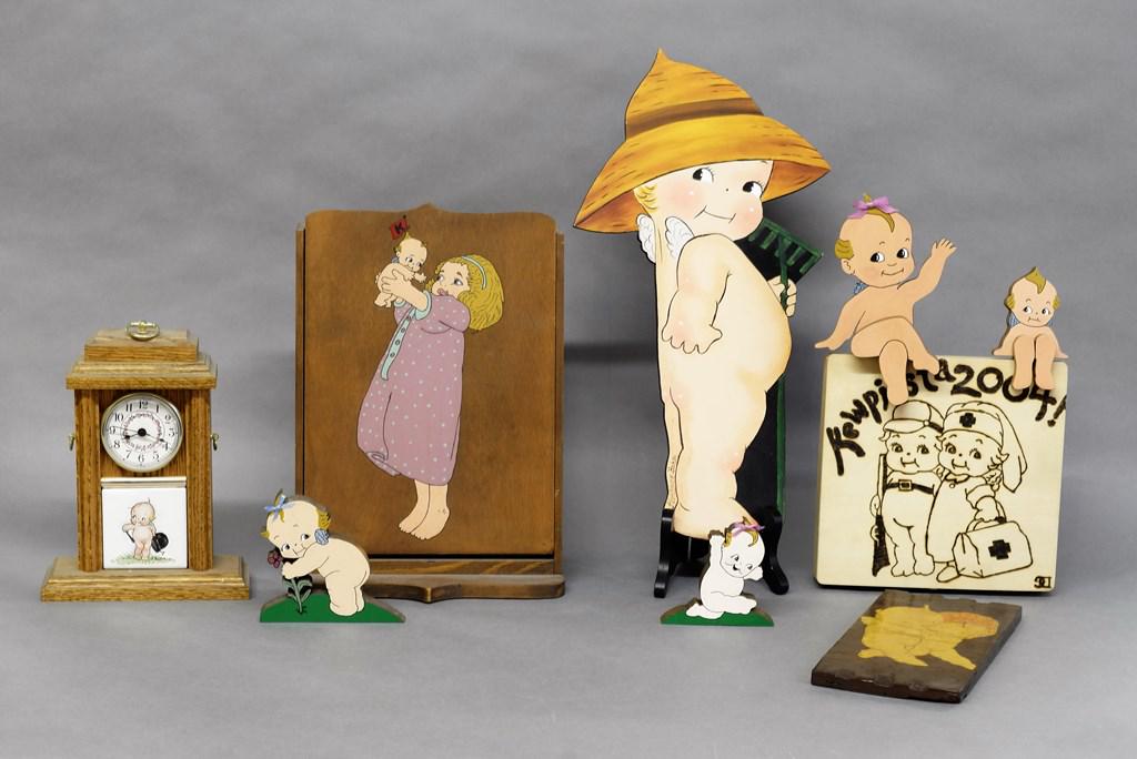Wood Kewpie Collectibles By Gwynn's & Others: Hand painted wood collectibles by The Gwynn's include upright sewing box with hinged lid 14"H, quartz clock, pyro decorated box and four Kewpie decorations, also includes Kewpie on Masonite by Florenc
