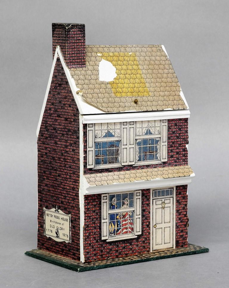 Small Scale Betsy Ross House Dollhouse: Small scale wood two room dollhouse with hinged front over two rooms, exterior covered in worn illustrated paper, comes with a selection of white plastic furniture, 7.5"W, 11"H, 5"D