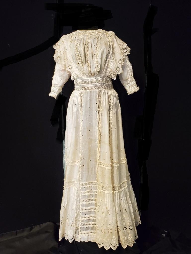 Victorian Tea Dress: White Victorian tea dress of white cotton lawn 3/4 length sleeves. The bottom of the skirt is lawn eyelet, the rest of the skirt has lace insertion intermittently with lace ruffle edges the bodice wai
