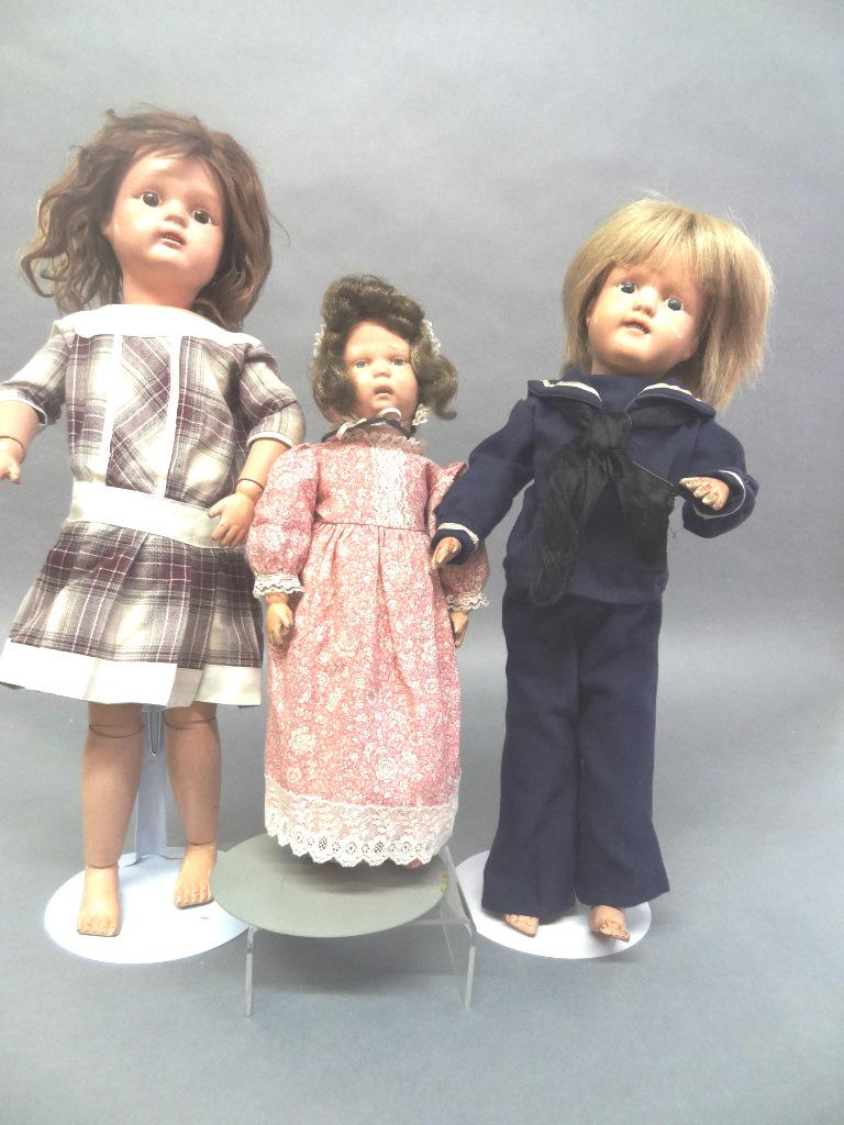Three Schoenhut Dolls: Three Schoenhut Dolls, 20" , 17" , 14" all have been repainted, all have new clothing, 17" has paper label, two others have incised wording on the backs. All three have holes in feet, bodies look good