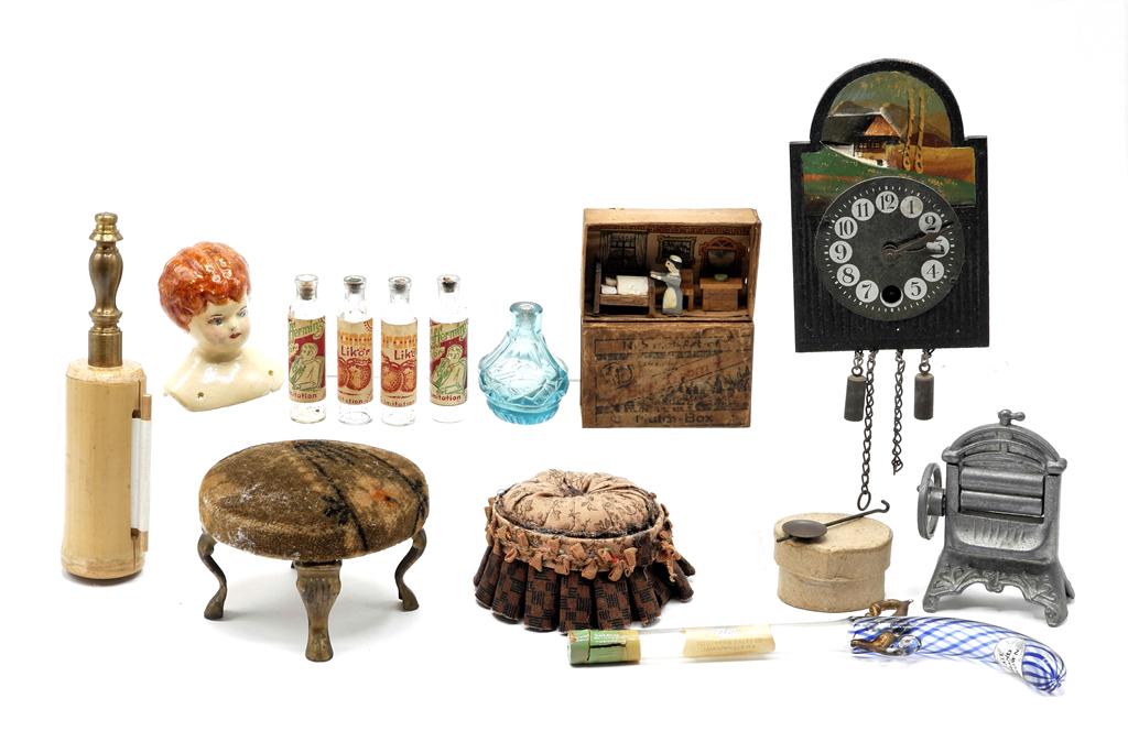 Assorted Old Dollhouse Accessories: Antique advertising ottoman pincushion with ormolu legs 3"D, fabric ottoman pincushion 2.5"D, cast metal clothes wringer, cut glass perfume bottle 1.5"H, antique German matchbox with tiny bedroom insi