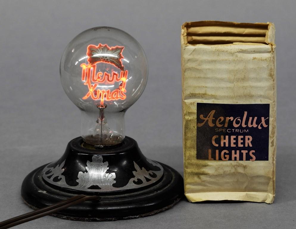 Vintage Aerolux Merry Xmas Bulb: Vintage Aerolux electric bulb with metal Christmas wreath and Merry Xmas on top of filament, includes original packaging 4"H, lamp not included