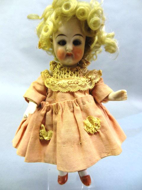 All Bisque Doll: All Bisque doll, German. All original with hair, 7", original clothing, curly wig, painted shoes and stocking, flirty eyes, closed mouth, one eye crossed.