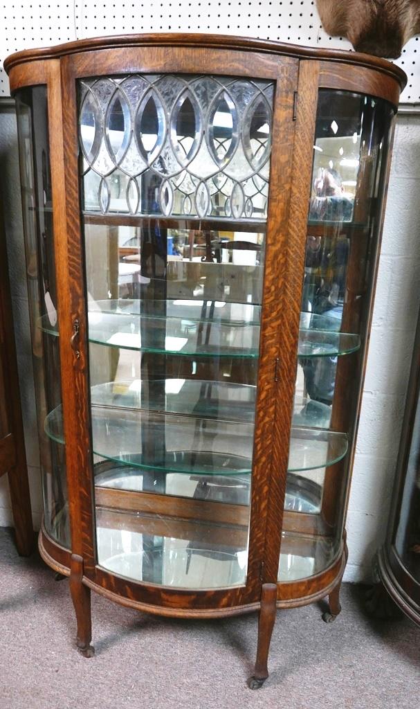 Antique Oak China Cabinet: Antique bow front oak china cabinet, bowed glass sides and bowed door with leaded glass panel containing bevel glass and part frosted glass, interior has three removable glass shelves, mirrored bottom