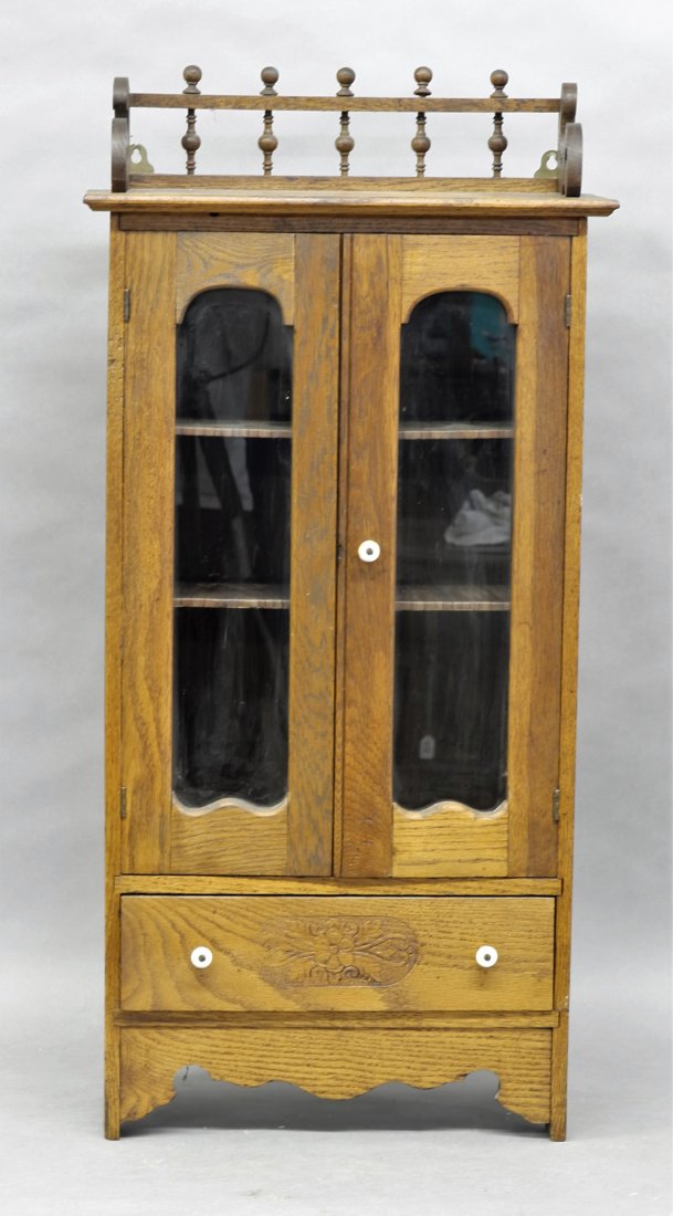 Antique Child: Antique oak child's armoire has scrolled gallery with rod and ball decoration, double glazed door over two adjustable shelves over a single drawer with pyro floral decoration and ceramic knobs, rear h