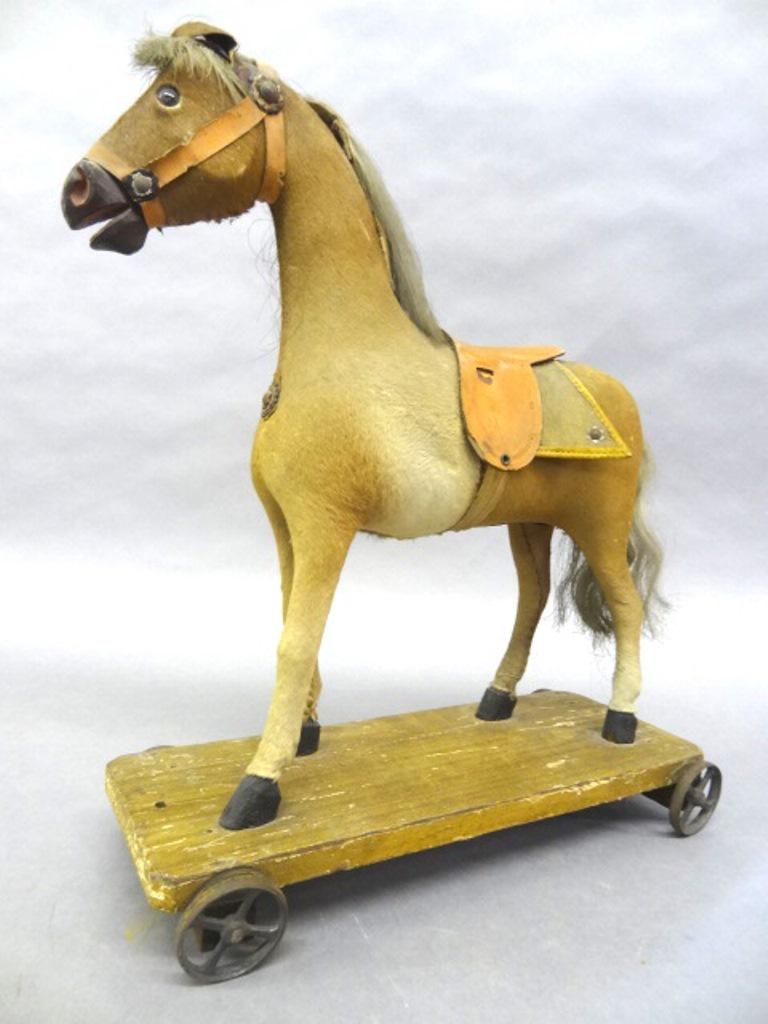 Antique Horse Pull Toy: Antique horse pull toy, fur covered body with real hair mane and tail, leather saddle with felt blanket, glass eyes, leather ears, composition mouth, harness tacks, wood platform with clipped corner h