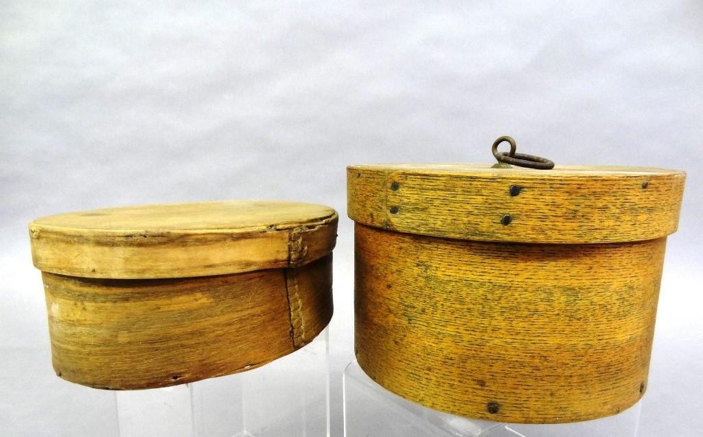 Two Antique Wood Pantry Boxes: Antique round lap jointed box with hand made nails, oak body with softwood top and bottom and an iron ring handle 7.5"D, 4.5"H, oval lap jointed box has sewn joints 7.25"L, 5.5"W, 3"H