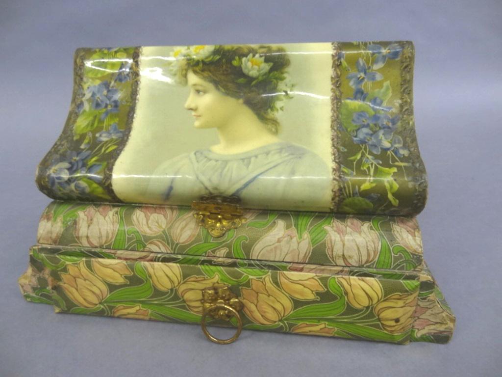1920: Lady's fitted dresser box, lid and drawer front cover in celluloid, rest covered in colorful paper, lid with beveled mirror covers a hand mirror, brush and comb, single drawer in bottom, 10.25"W, 6"H,