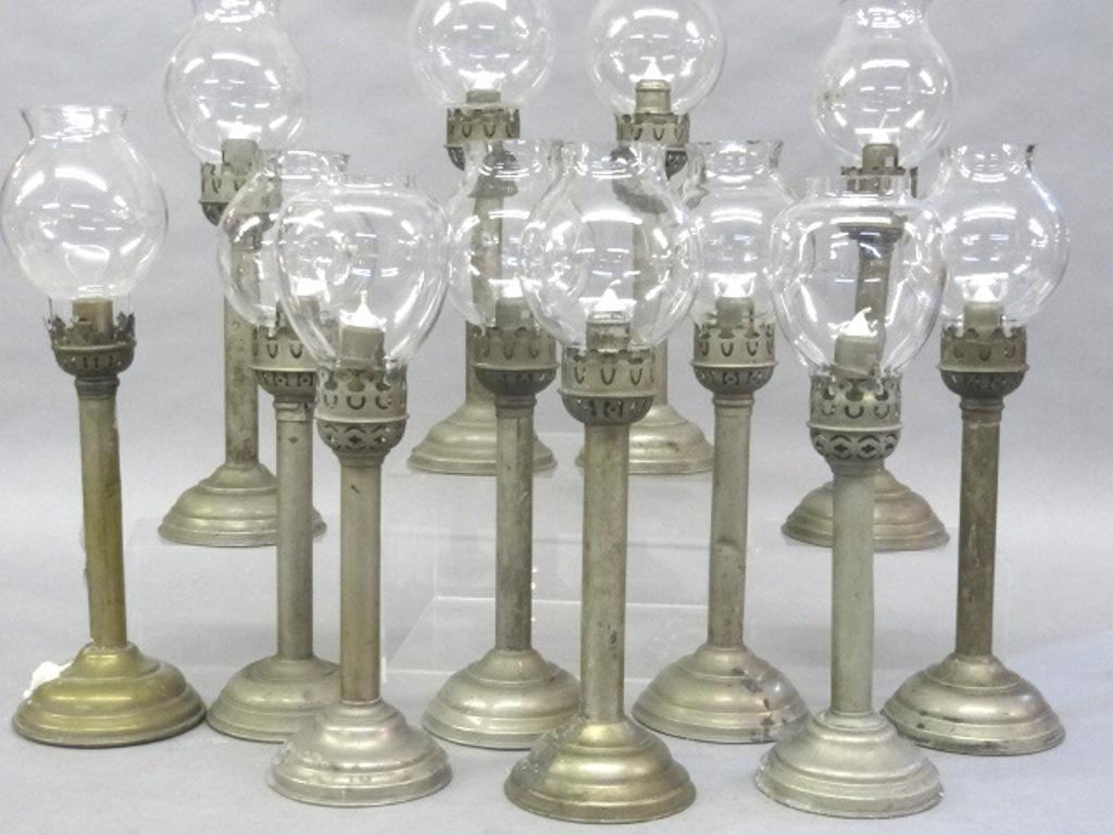 12 Spring Loaded Candlesticks With Globes: Group of 12 nickel plated candlesticks with spring loaded sockets and clear glass globes, eight are matching with anchor and star marks on bottom, average height 15"H