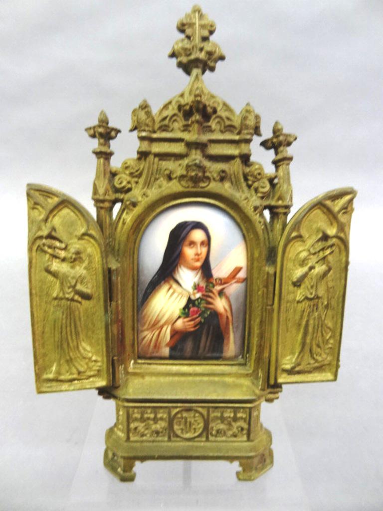 Antique Brass & Porcelain Icon: Antique cast brass icon with double hinged doors covering a portrait of Saint Theresa holding roses and a crucifix, 8"H, 5"W opened