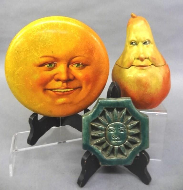 Artisan Ceramic & Paper Decorations: Artisan two piece pottery box depicting a face on a pear signed JM 6.5"H, earthenware glazed tile depicting the sun 4.25" square, paper over cardboard box depicting man on the moon 6.75"D
