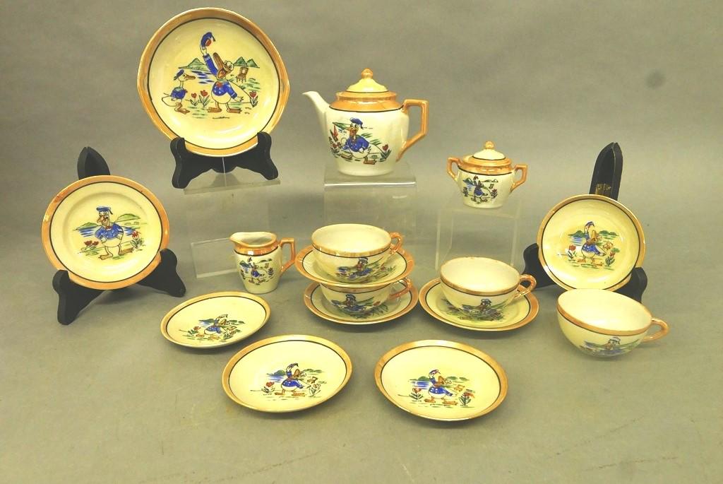 Vintage Child's Donald Duck Tea Set: Colorful vintage child's luster tea set, each piece with a picture of Donald Duck, includes Teapot 6"W signed "Donald Duck Copr. by Walt E. Disney Made In Japan", serving tray 6"W, four cups, four sau