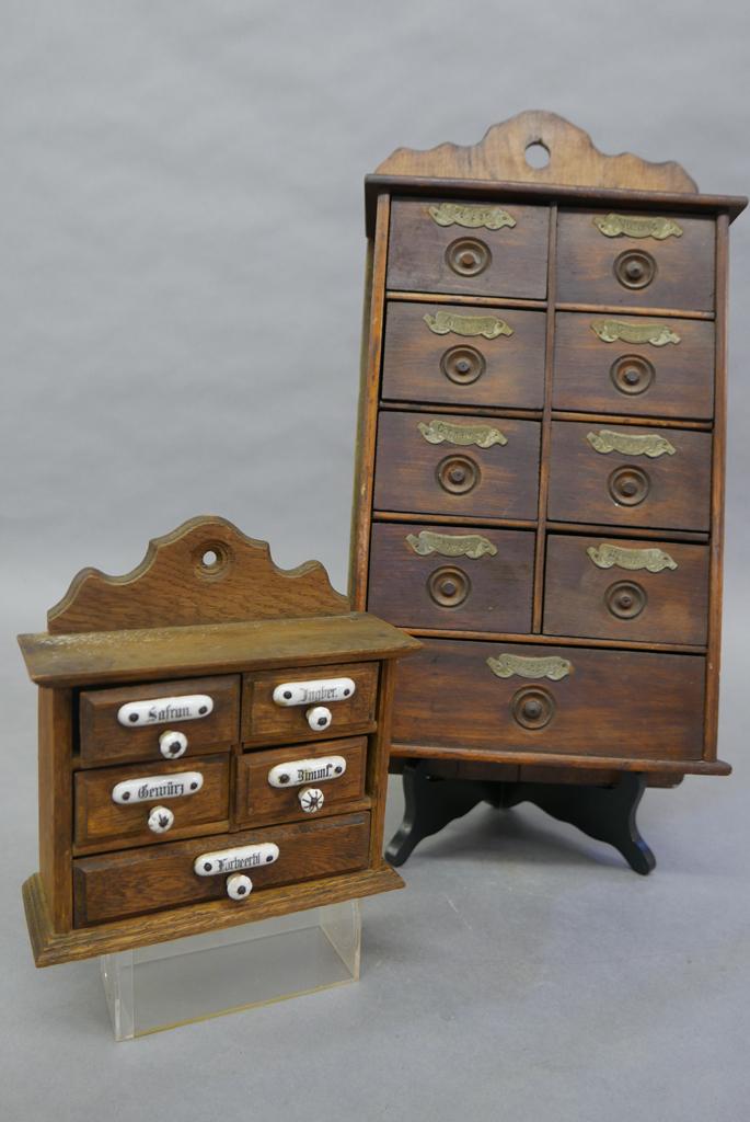 Two Vintage Hanging Spice Boxes: Small oak spice box has five drawers with ceramic labels and pulls 7.25"W, 7.5"H, large five drawer spice box has walnut drawer fronts with stamped tin labels 19.5"H, 9.5"W