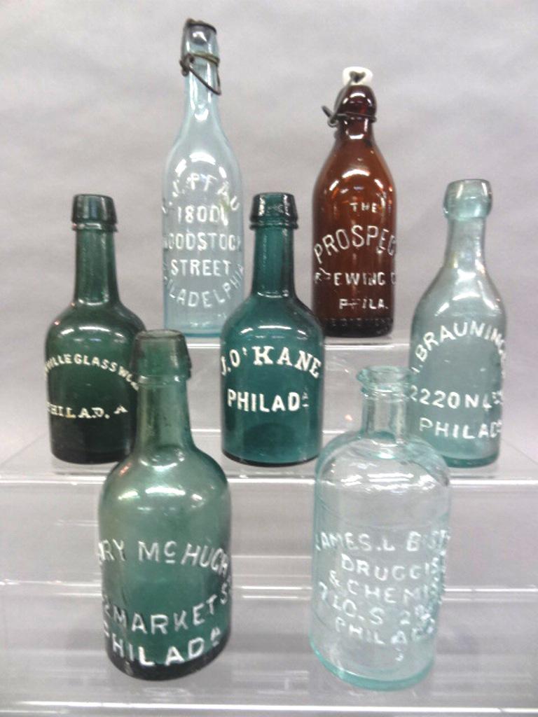 Three Antique Phila. Squat Beer Bottles & Others: Three early glass beer bottles from Philadelphia brewers, Dyottville Glass Works, Henry McHugh 1842 Market St., J. O'Kane 7"H, also includes The Prospect Brewing Co. 8"H, James L. Bispham Druggist & C