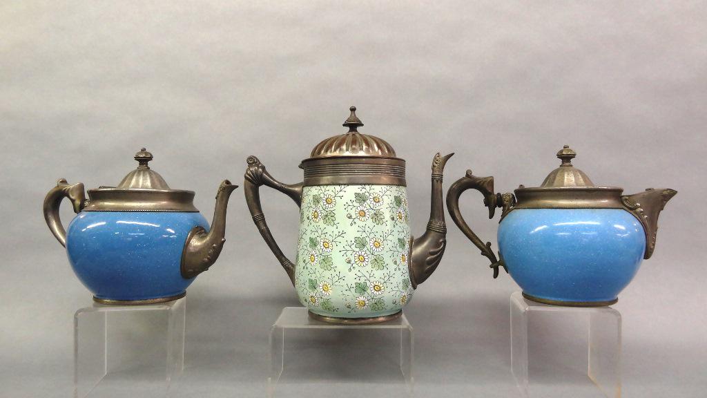 Manning Bowman Teapots & Coffee Pot: Two Manning Bowman enamelware and silver-plate teapots with different types of spouts 10"L, also an unsigned floral pattern enamelware and silver-plate coffee pot 10"H