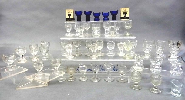 Group of Advertising & Clear Eye Cups: Group of five blue Wyeth advertising eye bath cups, 49 clear glass eye cups from various manufacturers in different patterns, 54 cup total