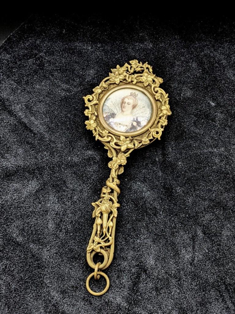 Antique Hand mirror With Inset Miniature Portrait: Antique European [probably French] cast brass hand mirror with bevel glass mirror on front and a hand painted portrait under glass on the reverse, 7.5"L, portrait 1.75"D
