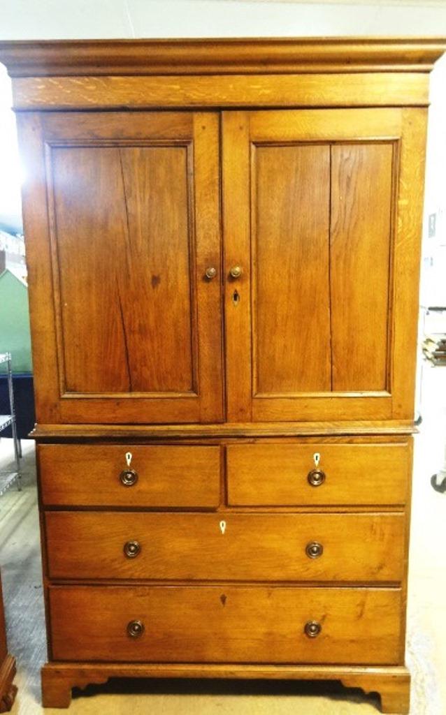 Antique Oak Linen Press: Antique English oak two piece linen press circa 1840, top has two paneled door covering two shelves, base has two half width drawers over two full width drawers with brass pulls and horn or bone escut
