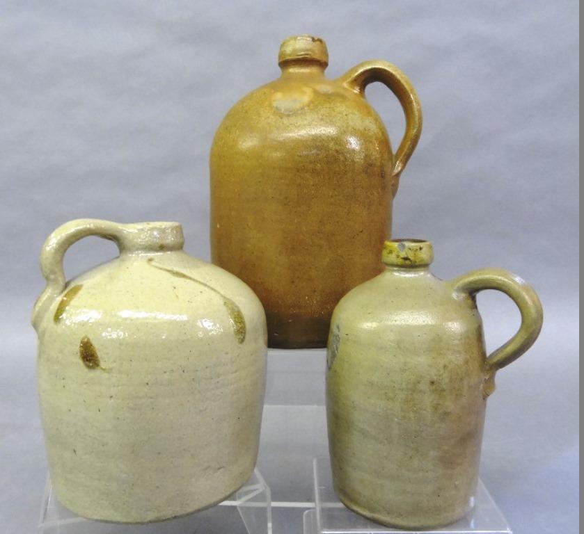 Three Antique Stoneware Jugs: Three antique stoneware jugs with applied strap handles, small jug with green/brown slip drip decoration 7.5"H, small jug with shallow lip chips 7.5"H, large jug with small lip chips 11.25"H