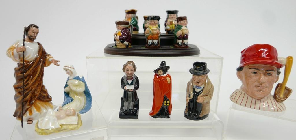 13 Small Royal Doulton Jugs & Figures: Group of Royal Doulton porcelain jugs and figures, tallest 5.75, Joseph HN3486, Mary HN3485, Jesus HN3487, Charles Dickens HN3448 special edition of 1500, Guy Fawkes HN3271, wood stand with six small 
