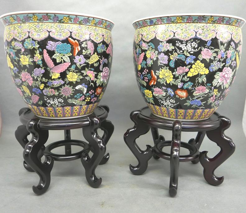 Pair Of Chinese Fishbowls On Stands: Pair of Chinese ceramic fish bowls hand painted with flowers and butterflies on the outside, flowers on the rim with fish and coral in the interior, 14.25"W, 12.25"H, also includes a pair of hardwood 