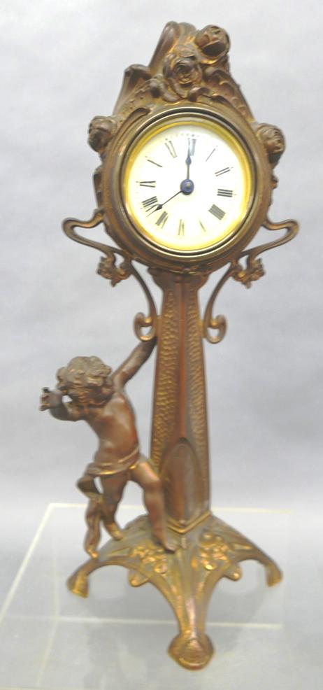 Antique Art Nouveau Gilt Bronze Clock: Beautiful original Art Nouveau clock circa 1900 - 1920, porcelain dial, face surrounded with roses, partially draped cherub hanging onto column, sun burst legs with water lilies, 16.5"H