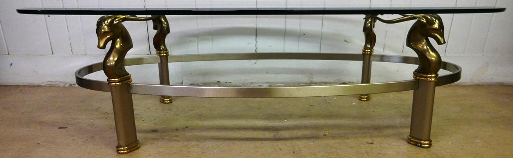 Antelope Decorated Coffee Table: Coffee table with beveled oval top, brass and steel base with antelope head legs 30" by 60" by 16"H