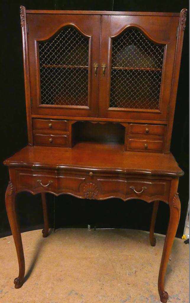 French Provencal Writing Desk: French Provincial style lady's writing desk, riser has door doors with wire mesh over one shelf and four small drawers, base has one wide drawer with shell carving, cabriole legs with shell carved kne